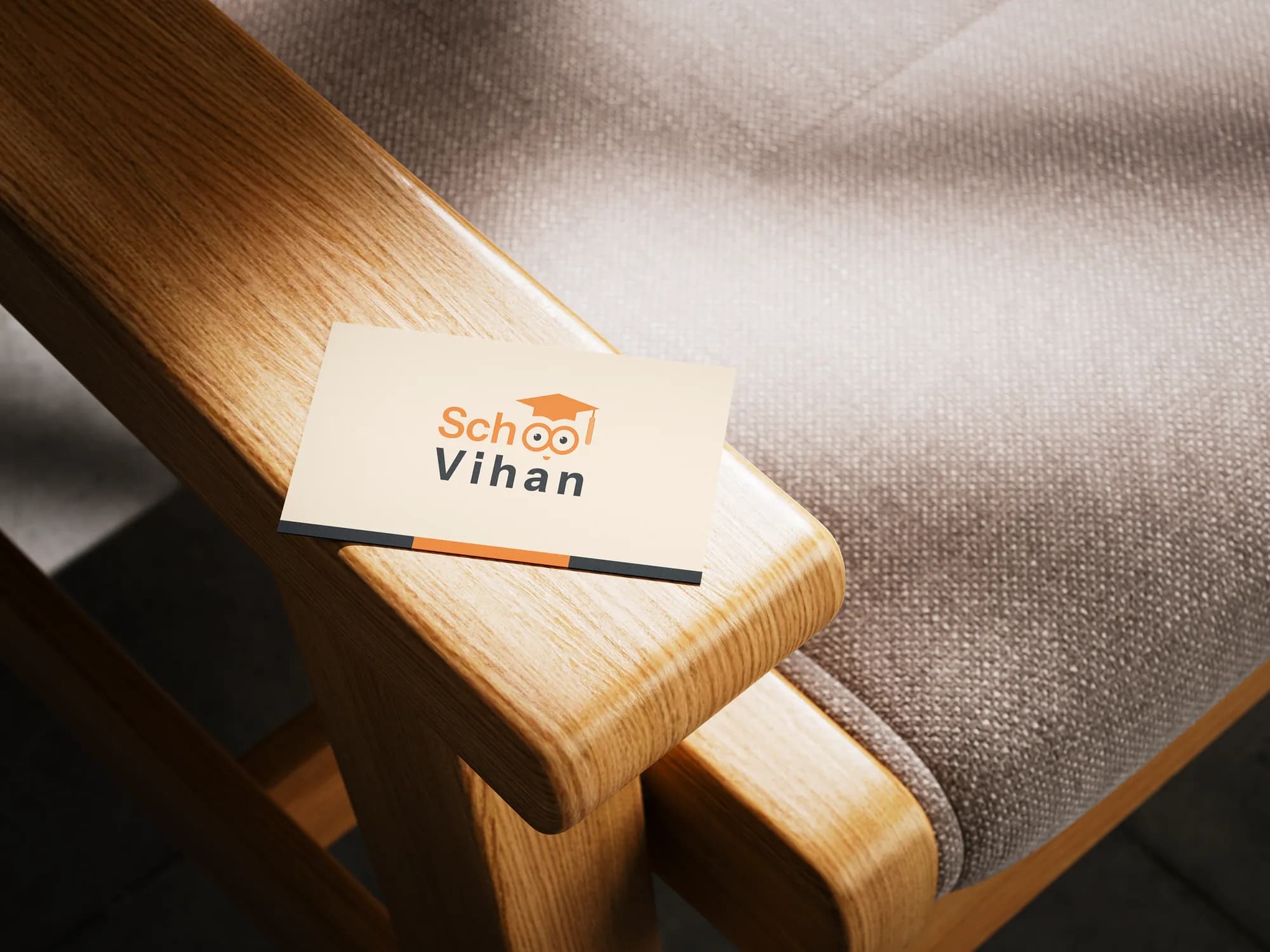 A Vihan School business card on the arm of a wooden chair