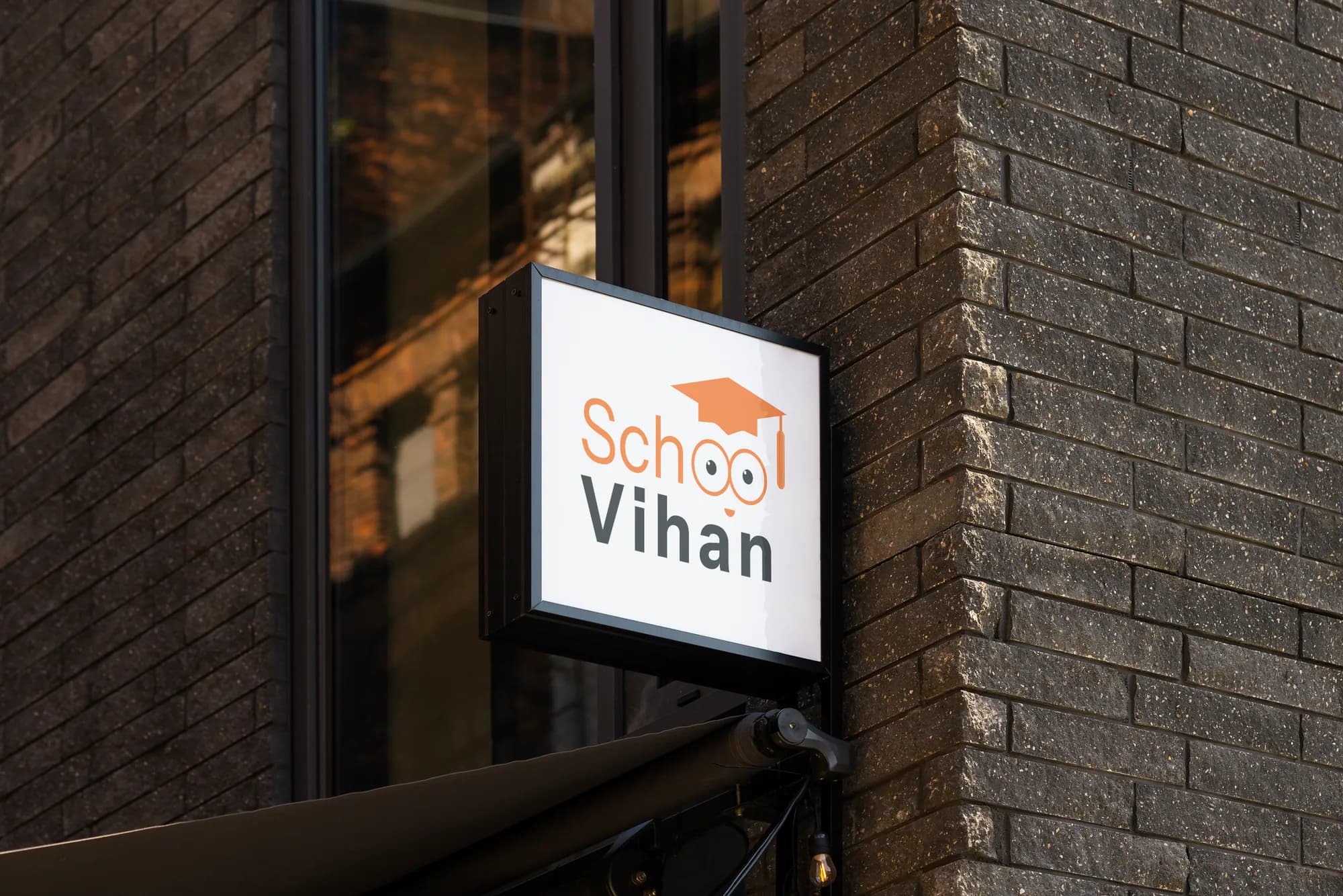 Illuminated Vihan School sign on a brick wall
